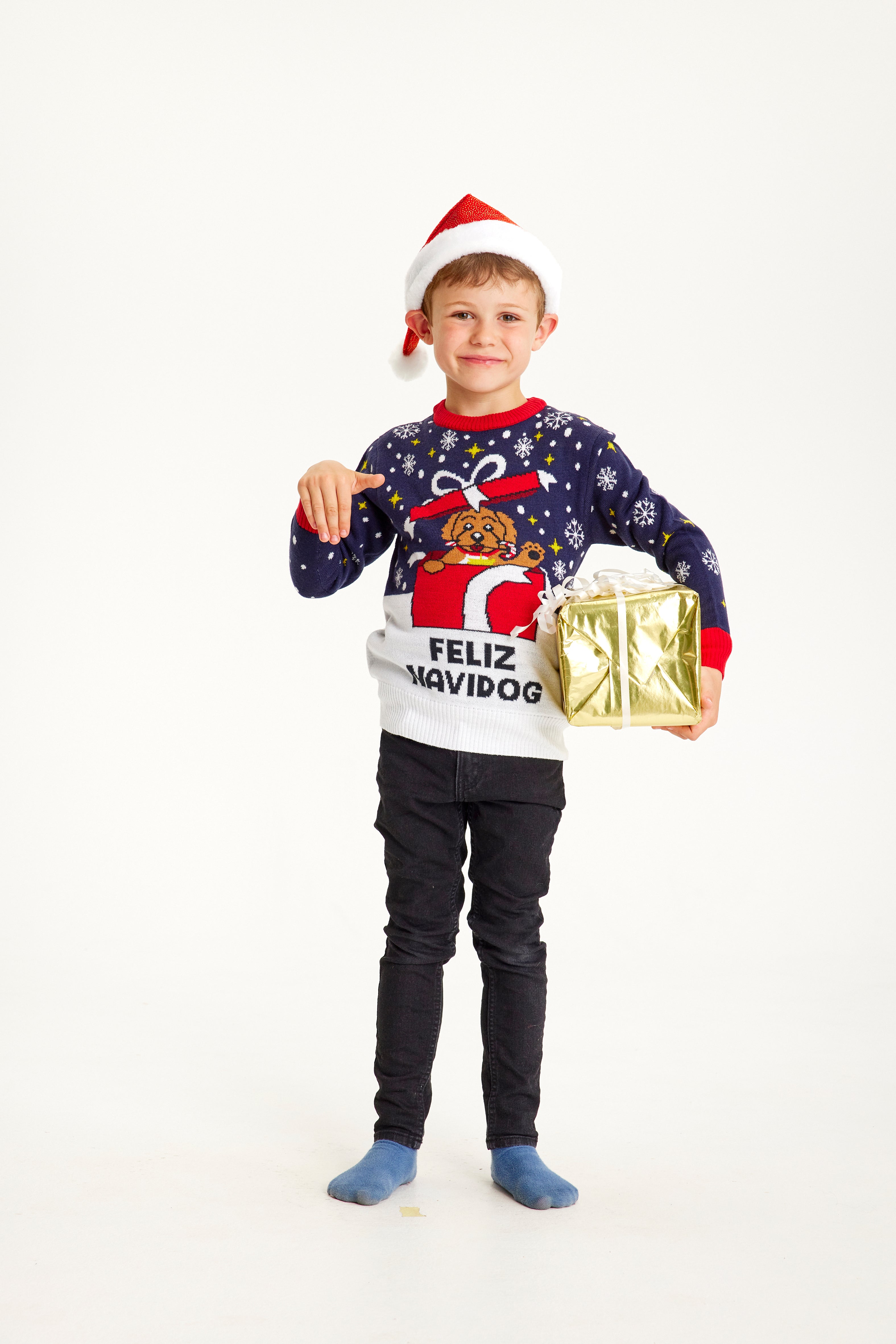 En dreng iført en julesweater med citatet "Feliz navidog".