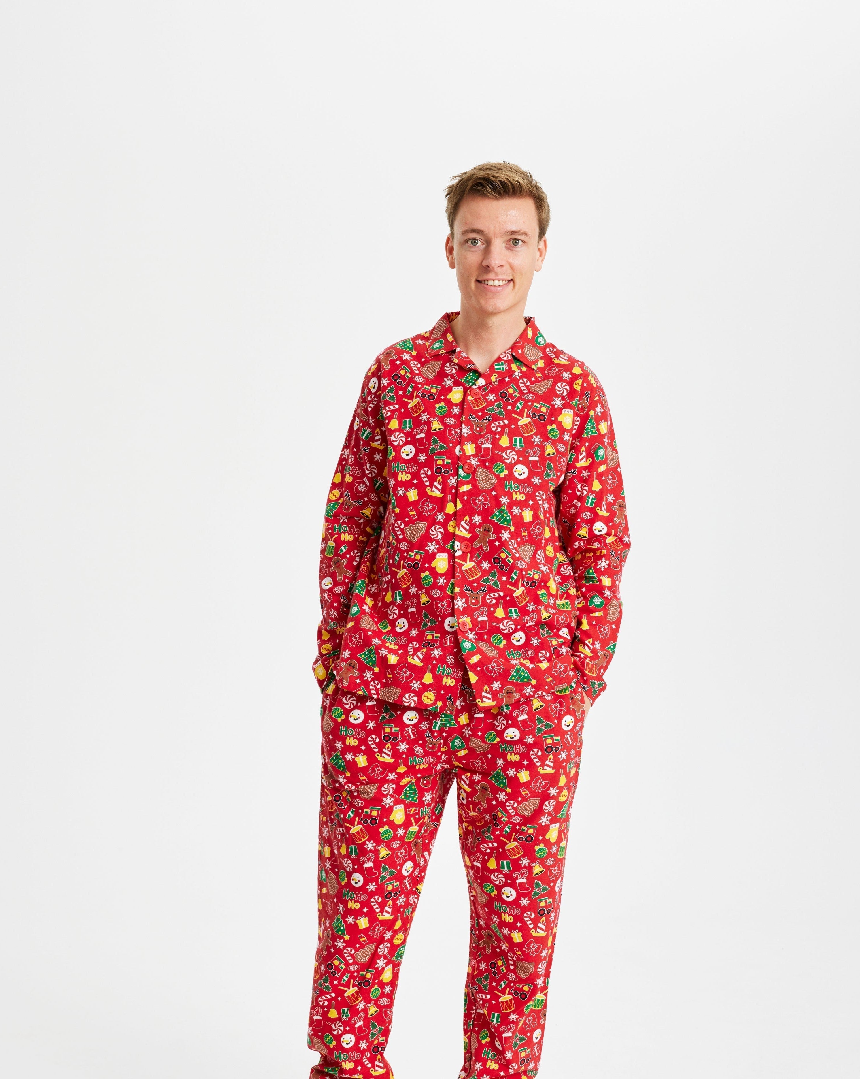 Een poserende man met een rode kerstpyjama.
