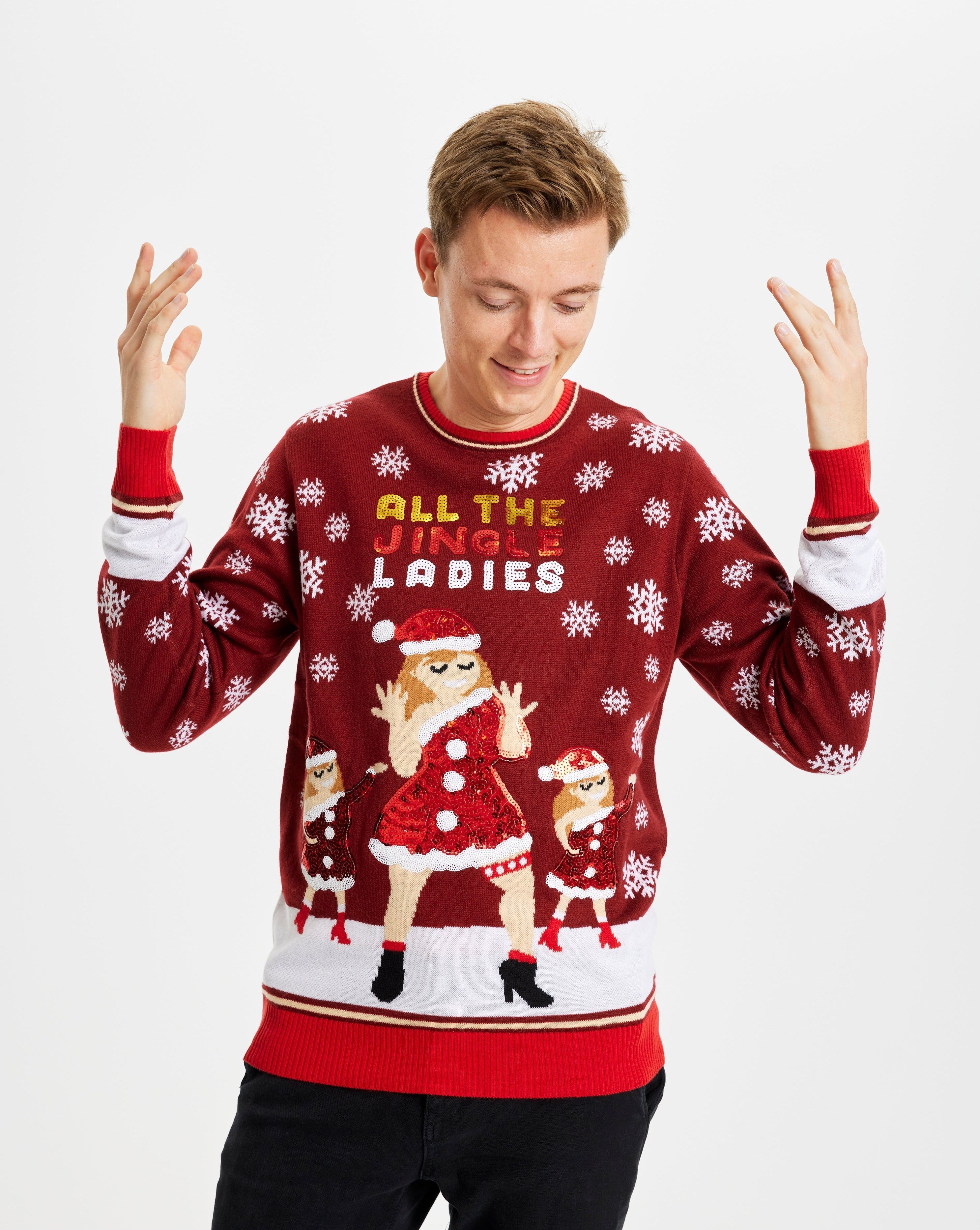Een man poseert terwijl hij een rode en witte kersttrui draagt met de quote "All My Jingle Ladies".