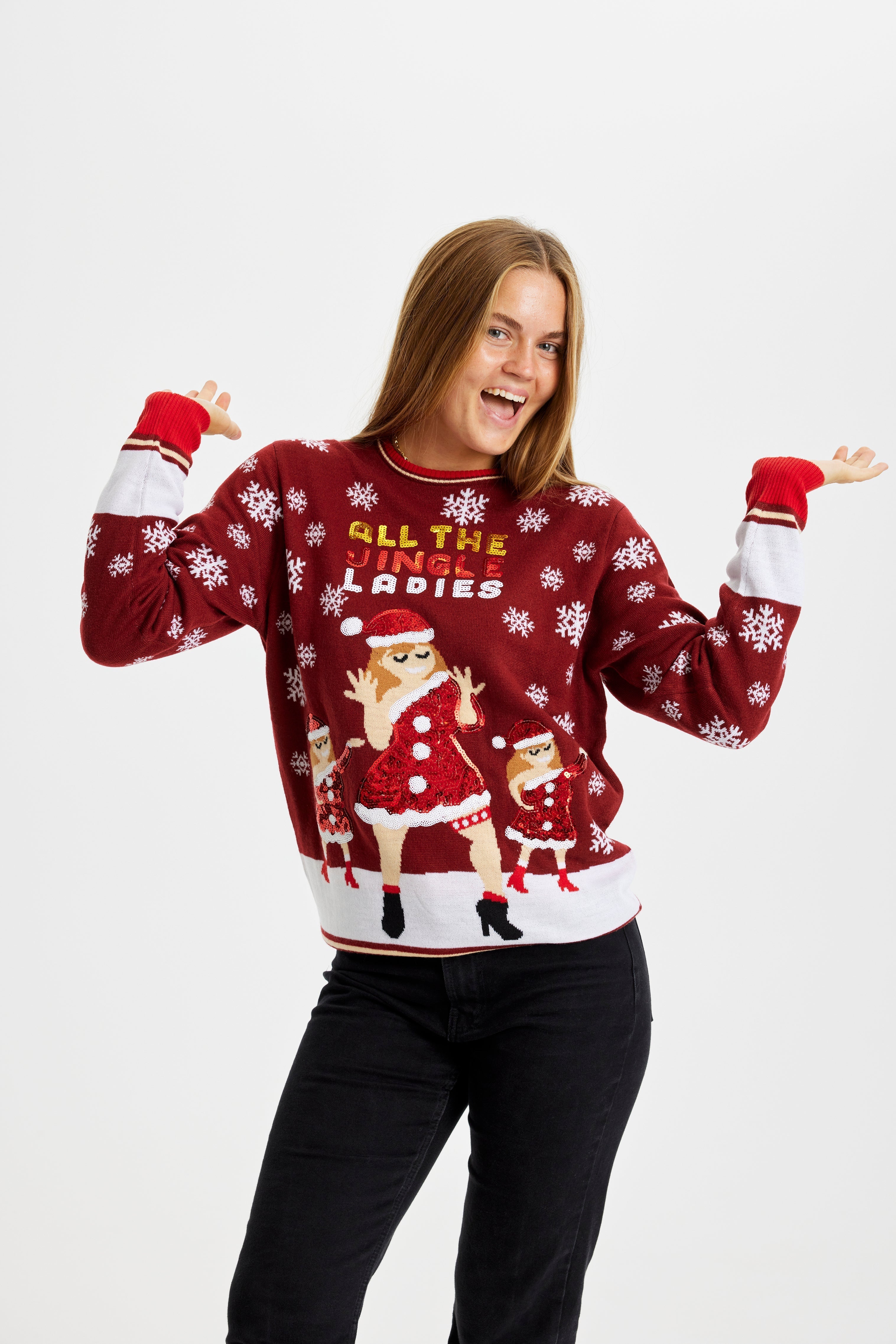 Een vrouw poseert terwijl ze een rode en witte kersttrui draagt met de quote "All My Jingle Ladies".