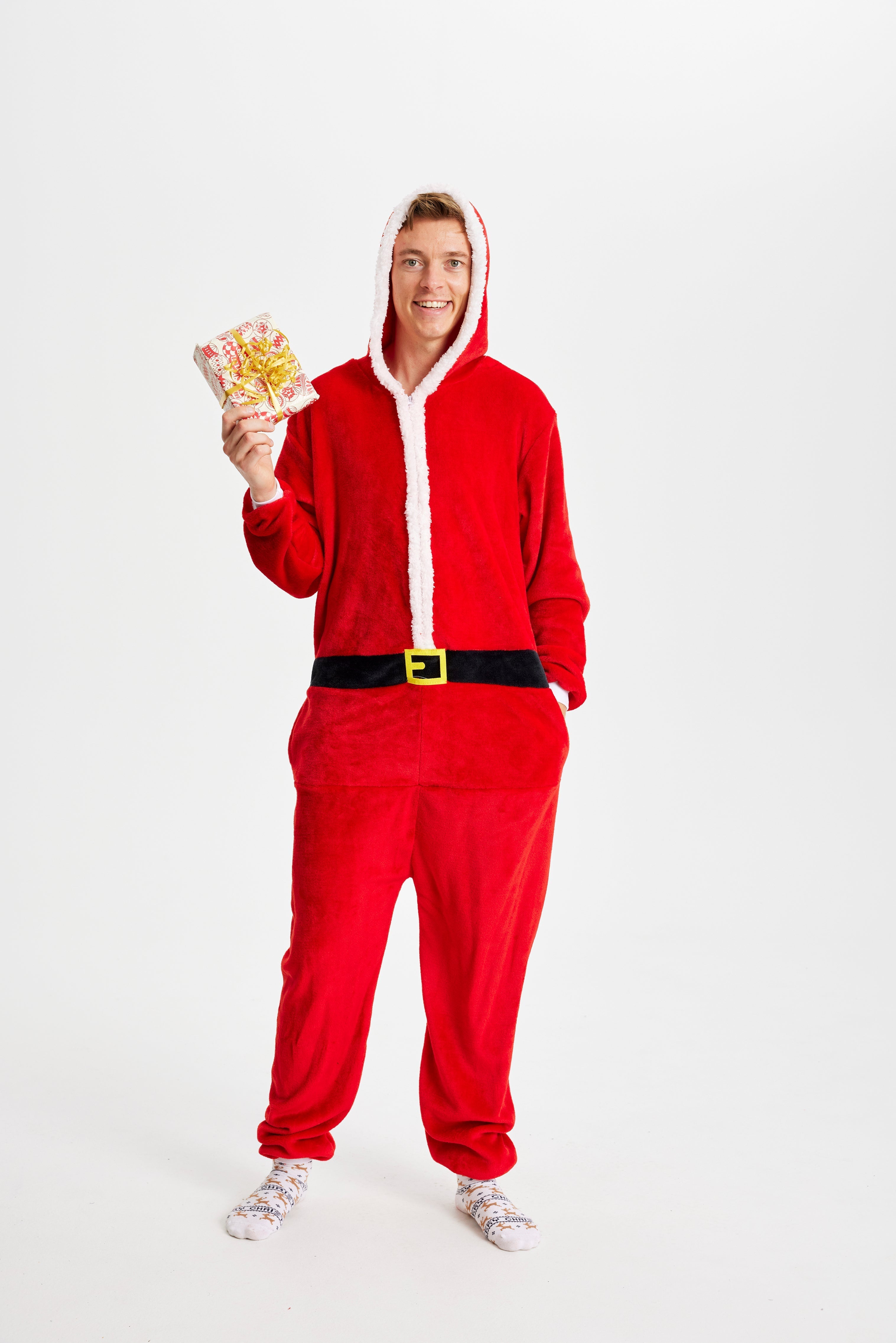 Een man poseert terwijl hij een kerstman kostuum draagt.