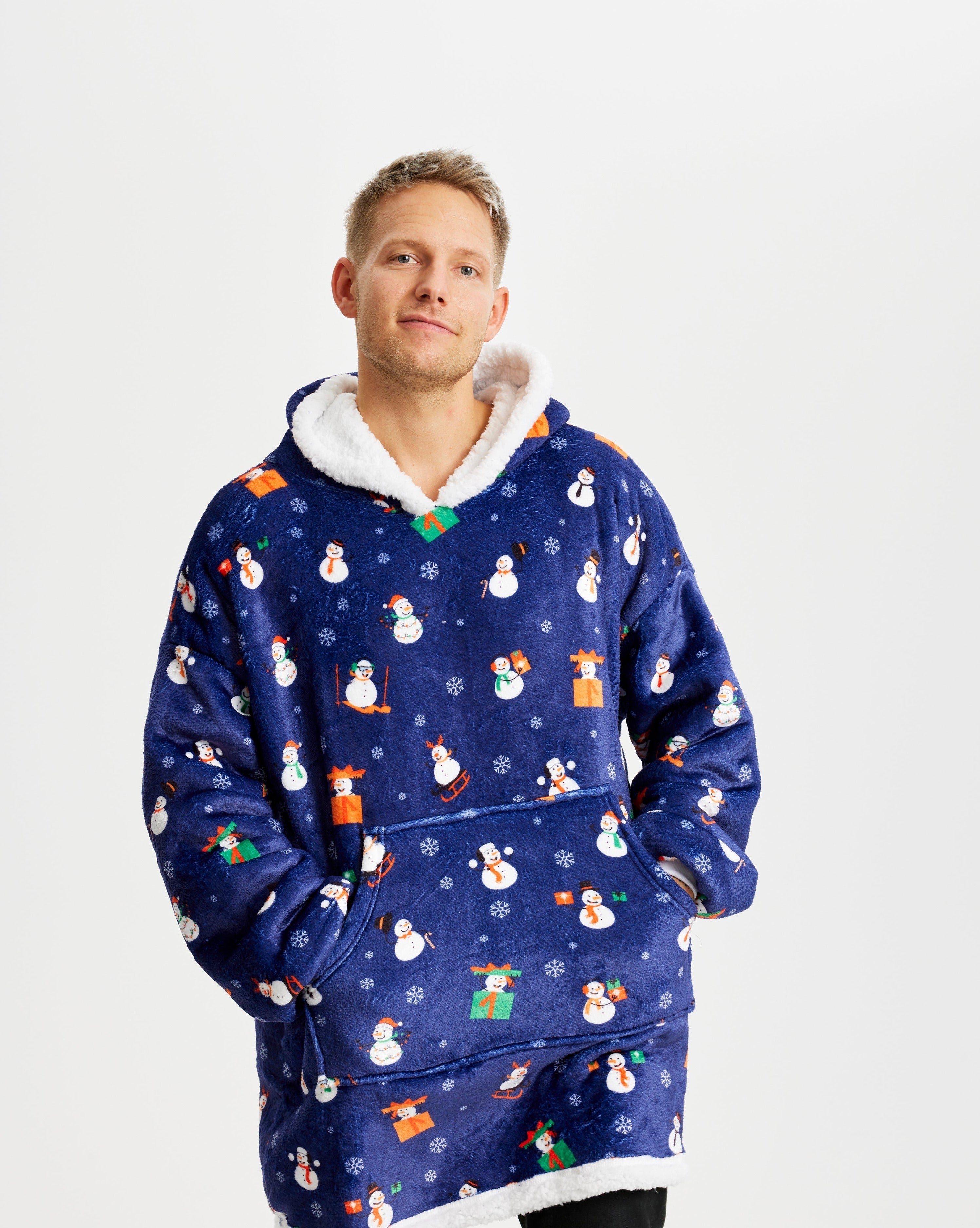 Een man draagt een blauwe kersttrui met sneeuwpoppen erop.