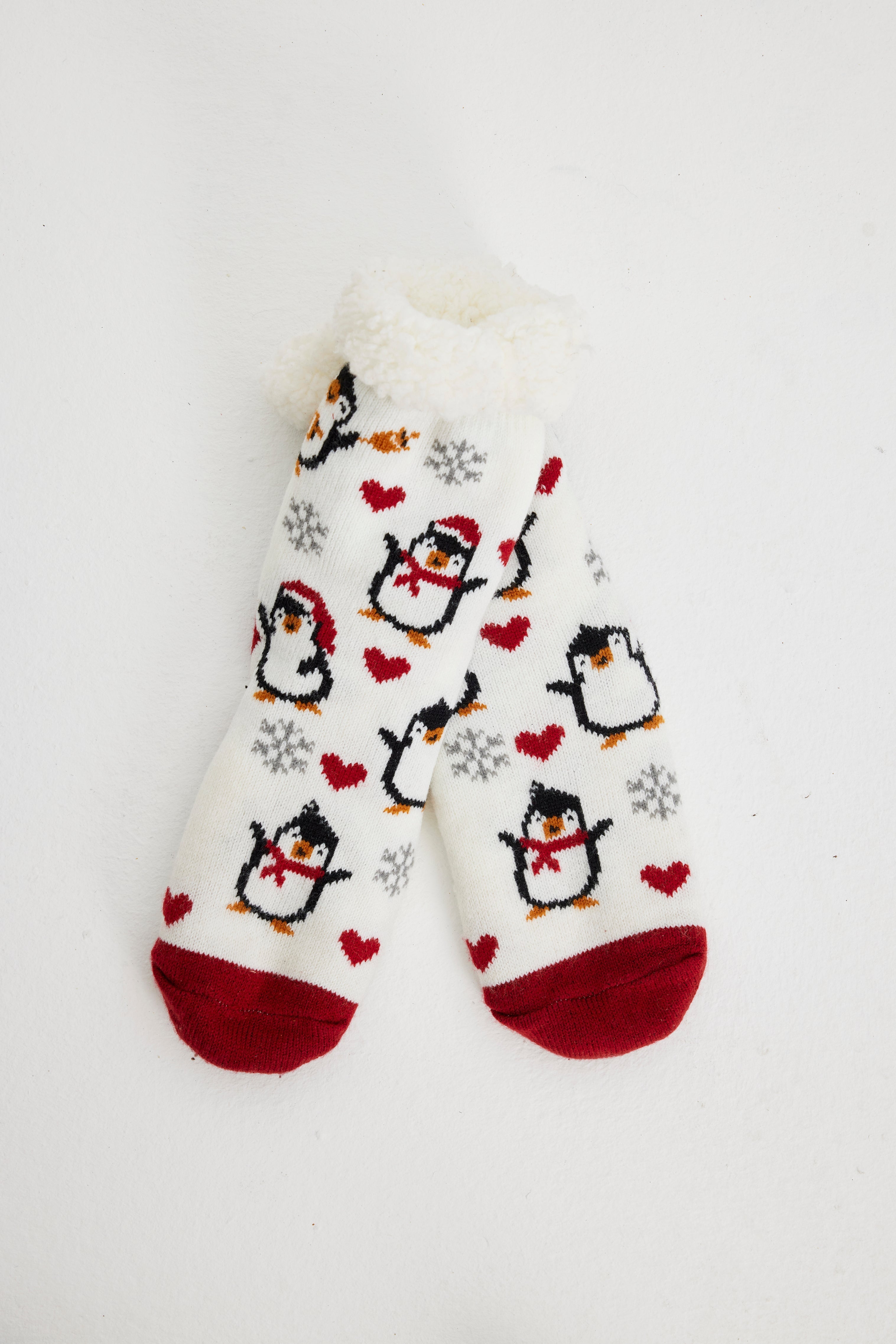 Witte en rode kerstsokken met pinguïns erop.