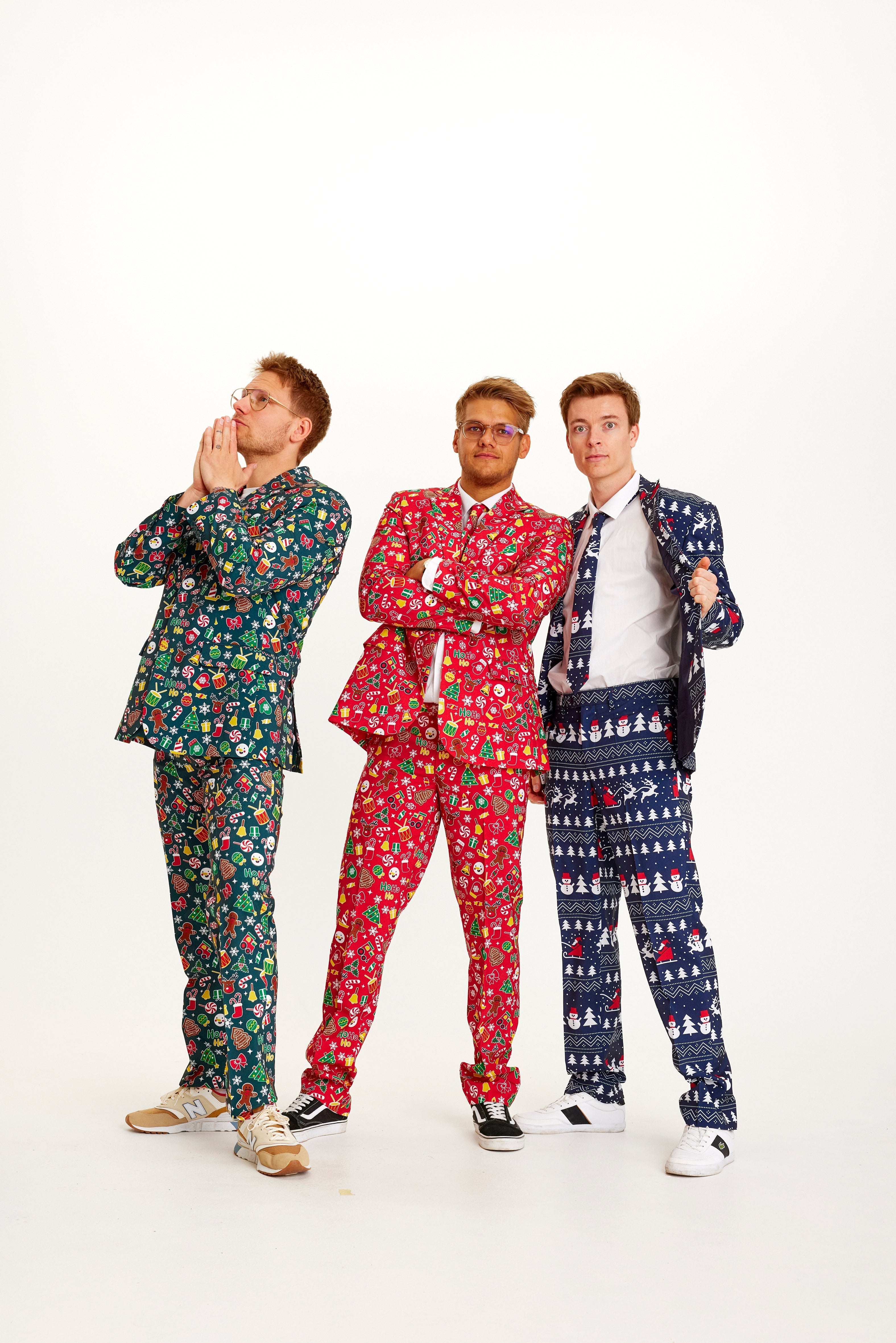 Drie mannen die elk een pak dragen met een kerstpatroon erop.